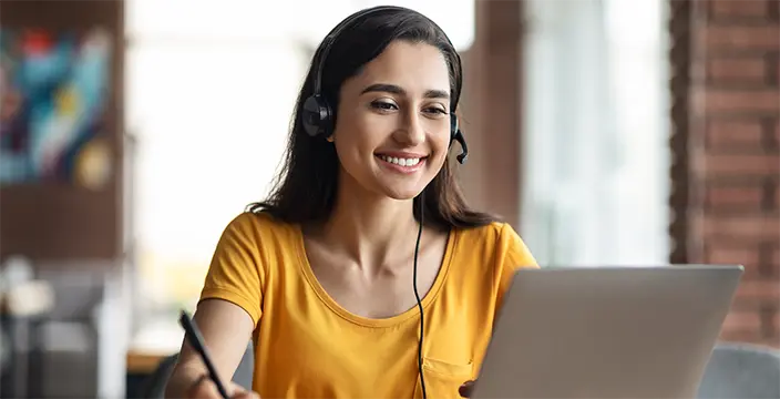 Woman with headset working on a laptop
